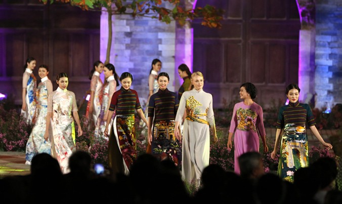 Nghệ sĩ, người mẫu và khách quốc tế trình diễn áo dài tại cổng thành Thăng Long. Ảnh: Hồng Vĩnh.