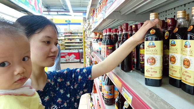 Người tiêu dùng lựa chọn nước mắm Phú Quốc tại siêu thị Fivimart (Hà Nội). Ảnh: Như Ý.