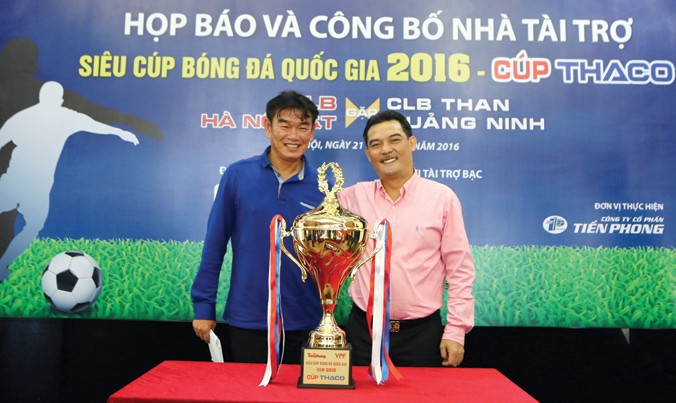 HLV Phan Thanh Hùng (trái) và Chủ tịch CLB Hà Nội T&T Nguyễn Quốc Hội bên Siêu cúp 2016. Ảnh: Như Ý.