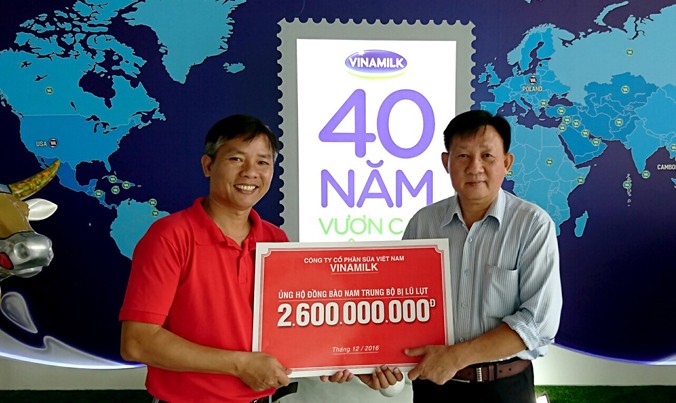 Ông Nguyễn Thanh Tú (phải) đại diện Công ty Vinamilk trao số tiền 2,6 tỷ đồng cho đại diện báo Tiền Phong. Ảnh: MQ.