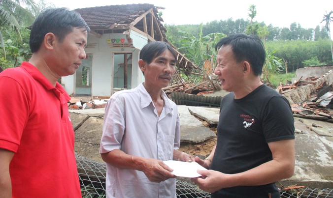 Ông Nguyễn Thanh Tú - Chánh văn phòng, Chủ tịch công đoàn Công ty Vinamilk trao tiền hỗ trợ cho gia đình bị thiệt hại do mưa lũ. Ảnh: Hoài Văn.