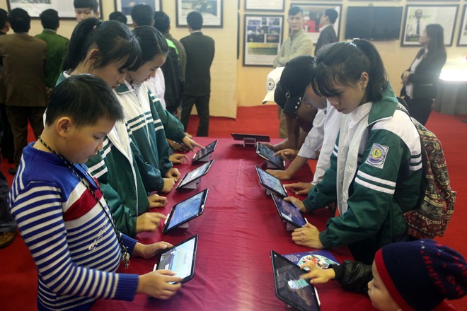 Các em học sinh xem triển lãm qua màn hình với công nghệ 3D. Ảnh: TTXVN.