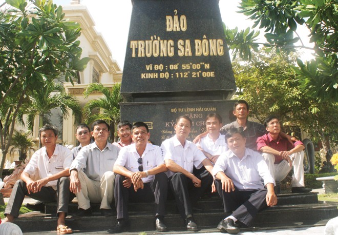 Những cựu binh Trường Sa nhiều thế hệ cùng ngồi bên mô hình cột mốc chủ quyền do anh Trần Văn Xuất làm ngay tại nhà mình. Ảnh Nguyễn Thành.