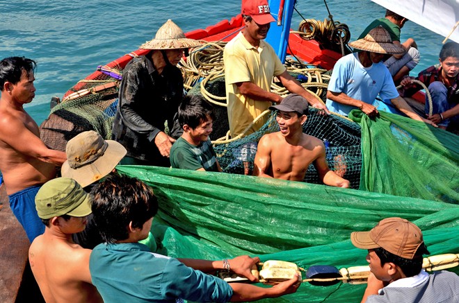 Ngư dân trên tàu cá ở cửa biển Sa Huỳnh hò dô kéo lưới. Ảnh: L.V.C.