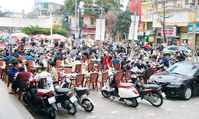 Một nhà hàng trên phố Lê Duẩn sử dụng vỉa hè làm nơi để xe và bày đặt bàn ghế cho thực khách ăn nhậu. Ảnh: Trường Phong.