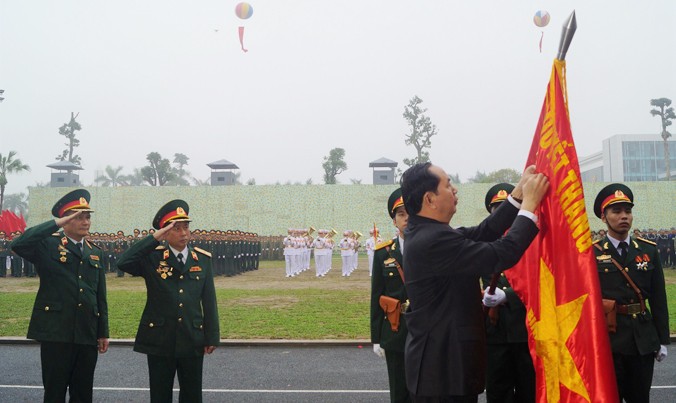 Chủ tịch nước Trần Đại Quang gắn Huân chương Quân công hạng Nhất lên Quân kỳ Quyết thắng của Binh chủng Đặc công. Ảnh: Nguyễn Minh.