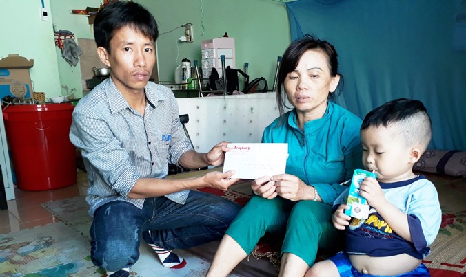 Đại diện báo Tiền Phong trao tiền giúp đỡ của bạn đọc đến mẹ con chị Quy.