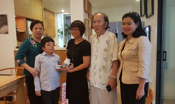 Phu nhân Chủ tịch nước Trần Đại Quang (bìa trái) thăm cậu bé Hà Đình Chí.