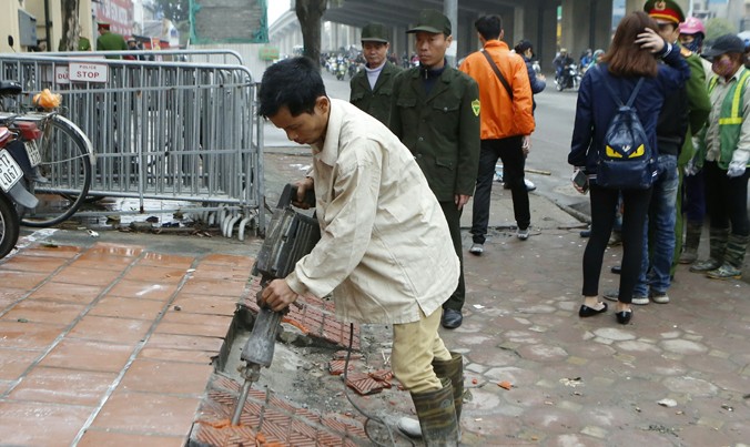Cơ quan chức năng đang tháo dỡ các công trình lấn chiếm hè đường Nguyễn Trãi, Hà Nội. Ảnh: Như Ý.