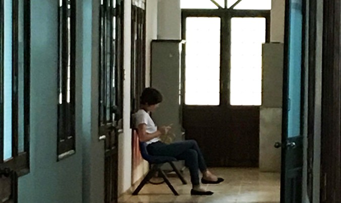 Cô Linh ngồi chờ trước cửa phòng giám đốc Sở Y tế.
