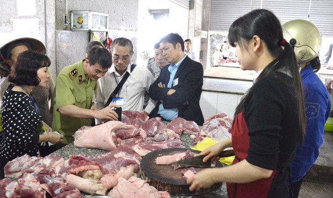 Đoàn cơ quan chức năng kiểm tra thực phẩm tại chợ Trương Định, Hà Nội. Ảnh: Hồng Vĩnh.