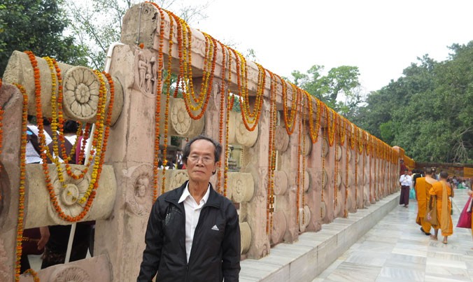Tác giả Trần Tuấn Mẫn bên di tích tường đá từ thời vua A Dục, bên cạnh cây bồ đề của Phật ở Bồ Đề Đạo Tràng (Boddhgaya), Ấn Độ. Ảnh: HAT.