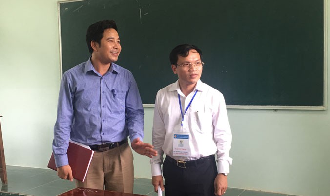 Ông Mai Văn Trinh (người đeo thẻ) kiểm tra cơ sở vật chất tại điểm thi trường THPT Nghi Lộc 5. Ảnh: Nghiêm Huê.