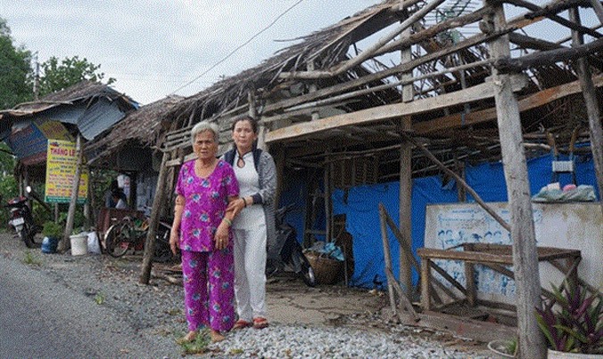 Bà Dương Thị Láng với con gái trước ngôi nhà sập.