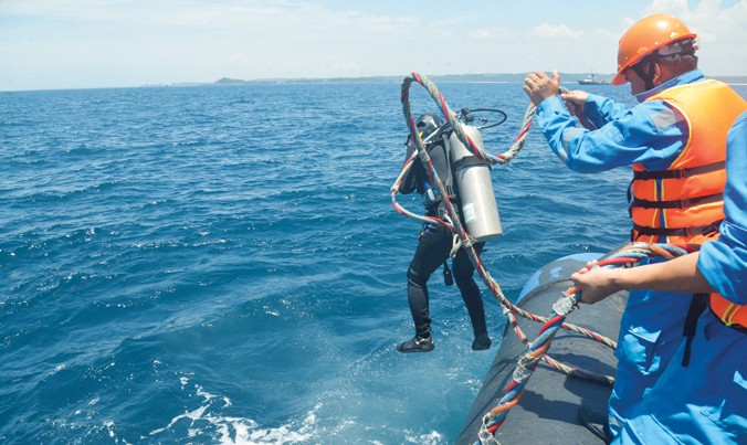 Thợ lặn chuẩn bị xuống đáy biển bảo dưỡng phao rót dầu số 0.