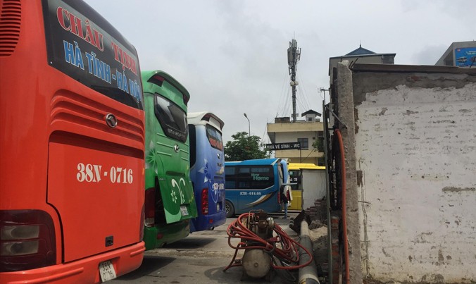 Hàng loạt xe khách trong bến Nước Ngầm nổ máy sát nhà dân. Ảnh: Nguyễn Hoàn.