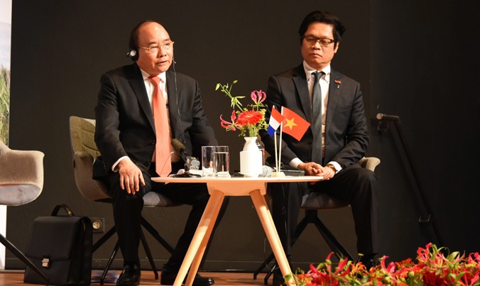 Thủ tướng Nguyễn Xuân Phúc và Chủ tịch Phòng Thương mại & Công nghiệp Việt Nam Vũ Tiến Lộc trao đổi với các doanh nghiệp. Ảnh: Văn Kiên.