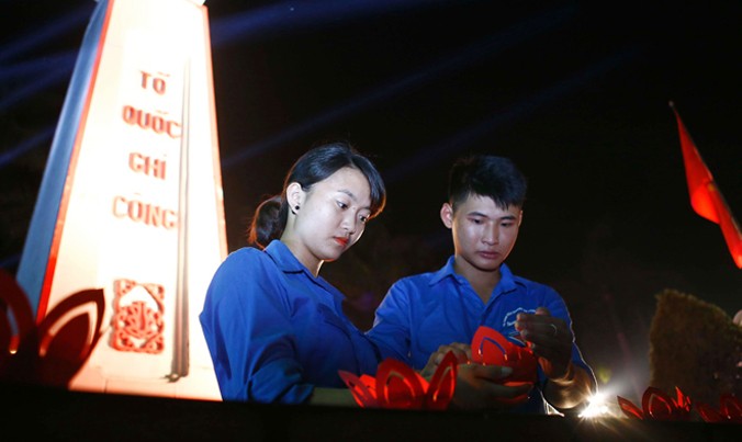 Sinh viên tình nguyện thắp nến tri ân các anh hùng liệt sỹ tại nghĩa trang liệt sỹ thành phố Hà Nội. Ảnh: Nhật Minh.