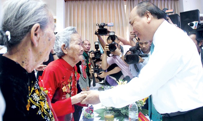 Thủ tướng Nguyễn Xuân Phúc ân cần thăm hỏi bà mẹ Việt Nam anh hùng. Ảnh: H. Văn.