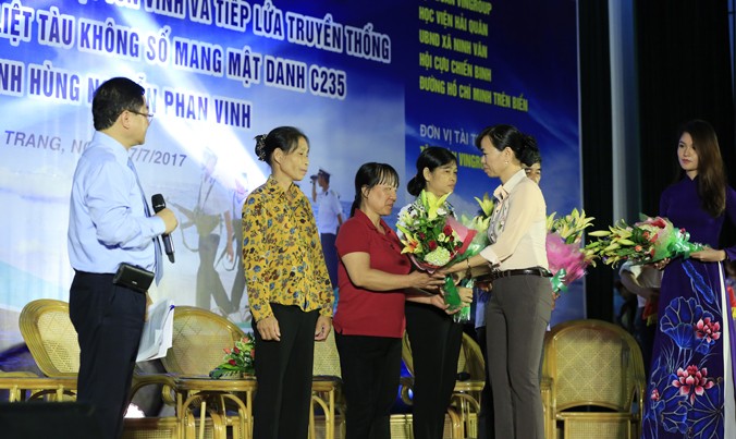 Chủ tịch xã Ninh Vân và Á hậu Thùy Dung (bìa phải) tặng hoa các thân nhân Anh hùng liệt sỹ tàu Không số C235. Ảnh: Hồng Vĩnh.