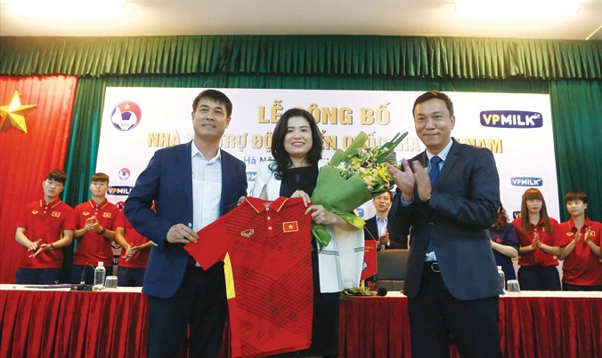 HLV Hữu Thắng trao tặng áo đấu của ĐTQG cho nhà tài trợ, Chủ tịch HĐQT kiêm Tổng giám đốc VPmilk Nguyễn Thị Thu Phương. Ảnh: VSI.