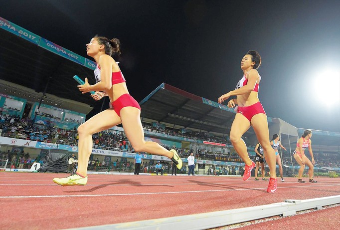 Nguyễn Thị Huyền (trái) nhận gậy từ đồng đội Hoàng Thị Ngọc trên đường chạy 400m nữ giải vô địch châu Á. Ảnh: AAA.
