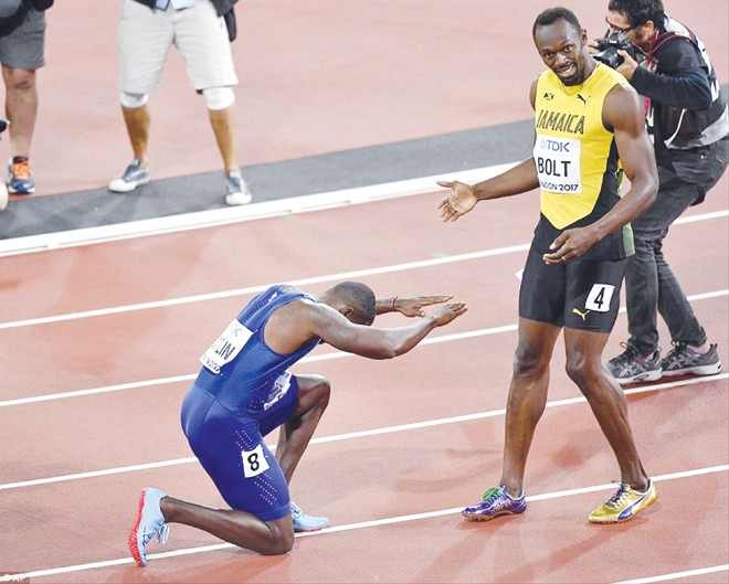 Nhà vô địch Justin Gatlin quỳ gối tỏ lòng ngưỡng mộ với Usain Bolt sau lần cuối cùng tia chớp người Jamaica sải bước trên đường chạy 100m. Ảnh: AP.