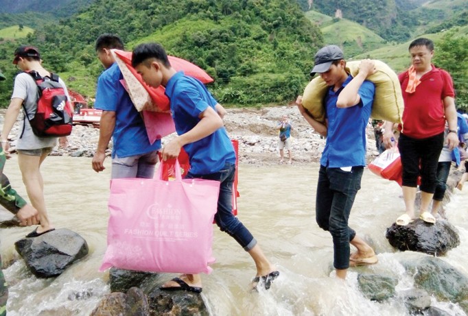 Các ĐVTN đi bộ vượt suối mang hàng cứu trợ vào cho bà con vùng lũ Mường La. Ảnh: Q.L.