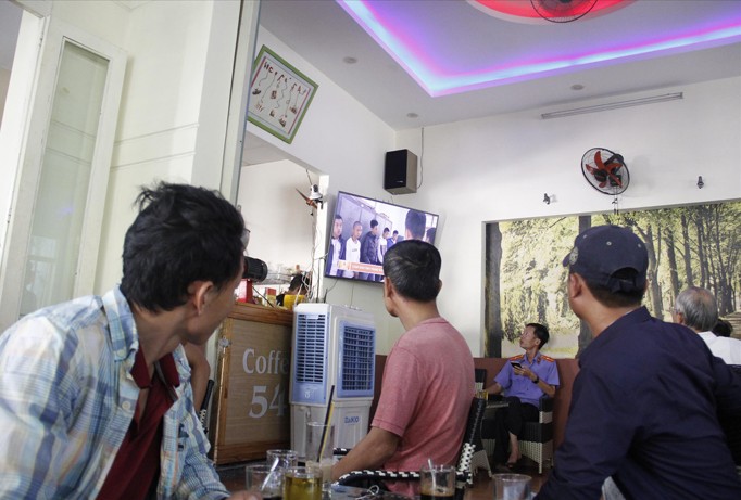 Thanh thiếu niên chăm chú xem clip về bắt tội phạm trong quán cà phê. Ảnh: Thanh Trần.