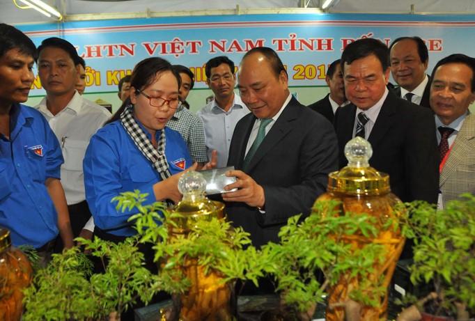 Thủ tướng Nguyễn Xuân Phúc tham quan sản phẩm đinh lăng của anh Võ Minh Nhựt. Ảnh: Hòa Hội.