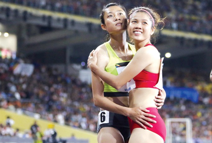 Hai VĐV Lê Tú Chinh, Lê Thị Mộng Tuyền hồi hộp xem lại hình ảnh chạy chung kết 100m nữ, với ngôi vô địch thuộc về Tú Chinh. Điền kinh là đội tuyển thành công nhất, đóng góp nhiều HCV nhất cho Đoàn TTVN tại SEA Games 29. Ảnh: VSI.