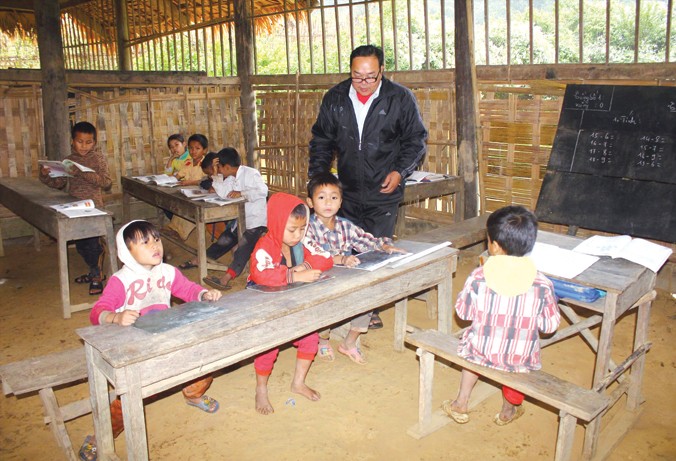 Thầy giáo Lô Văn Lan dạy chữ cho học trò bản Huồi Máy.