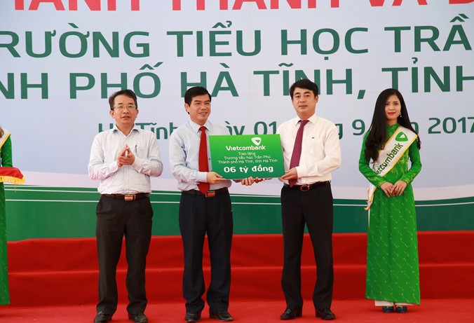 Ông Nghiêm Xuân Thành - Chủ tịch HĐQT Vietcombank (thứ 2 từ phải sang) trao tượng trưng số tiền 6 tỷ đồng của Vietcombank tài trợ kinh phí xây dựng Trường tiểu học Trần Phú (Hà Tĩnh).