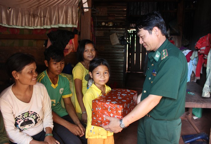 Thiếu tá Vũ Văn Hoằng tới thăm, tặng quà gia đình chị Rơ Mah H’Bri. Ảnh: Trúc Hà.