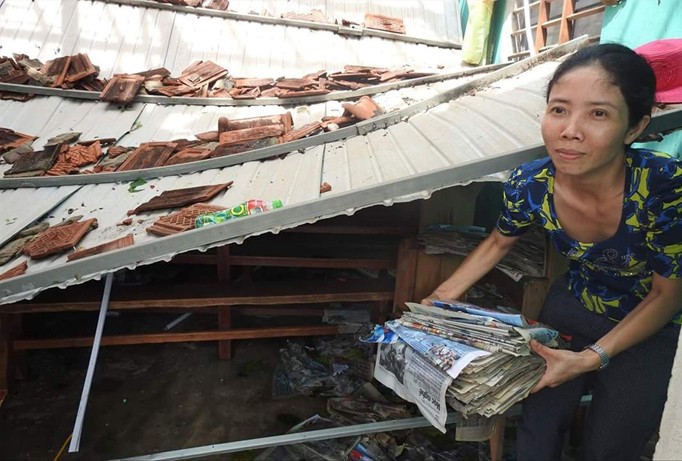 Một nữ giáo viên ở Quảng Bình lục tìm trong đống đổ nát được một ít sách báo ướt mèm.