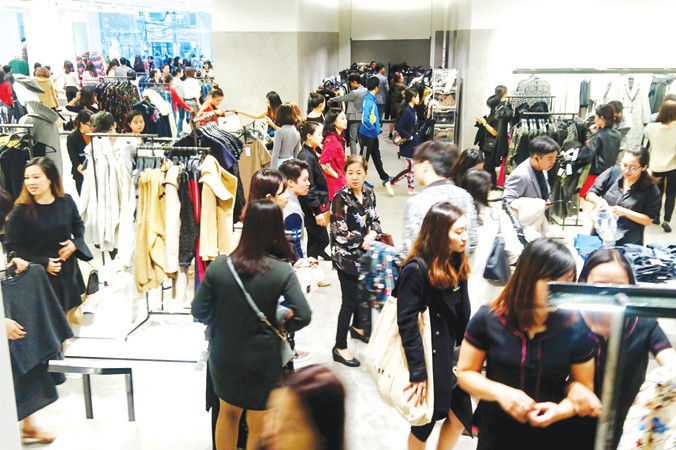 Người dân mua sắm quần áo tại Trung tâm mua sắm Vincom (Hà Nội). Ảnh: Như Ý.