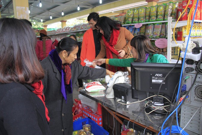 Người dân mua hàng tại phiên chợ Tết do Hapro tổ chức tại xã Đồng Tân (Ứng Hòa, Hà Nội).