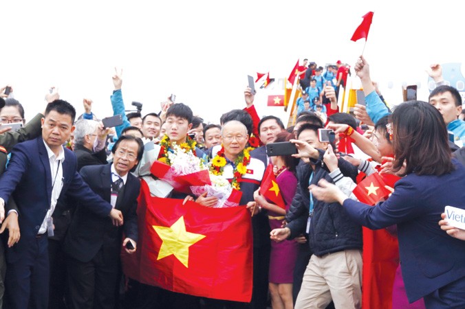 Người hâm mộ đón đội U23 Việt Nam tại chân máy bay khi từ Thường Châu, Trung Quốc trở về. Ảnh: Hồng Vĩnh.