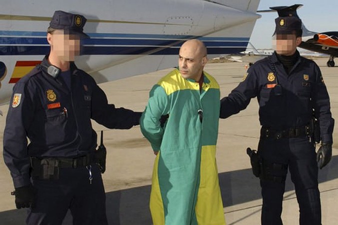 Farid Hilali bị hai cảnh sát Tây Ban Nha áp tải tại căn cứ không quân Torrejon de Ardoz, ngoại ô Madrid, năm 2008. Ảnh: EPA.