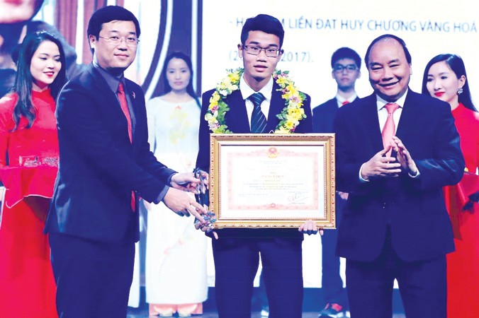 Thủ tướng Nguyễn Xuân Phúc và Bí thư thứ nhất T.Ư Đoàn Lê Quốc Phong trao Bằng khen cho GMTVNTB 2017 Đinh Quang Hiếu, người đã đạt 2 HCV Hóa học quốc tế.