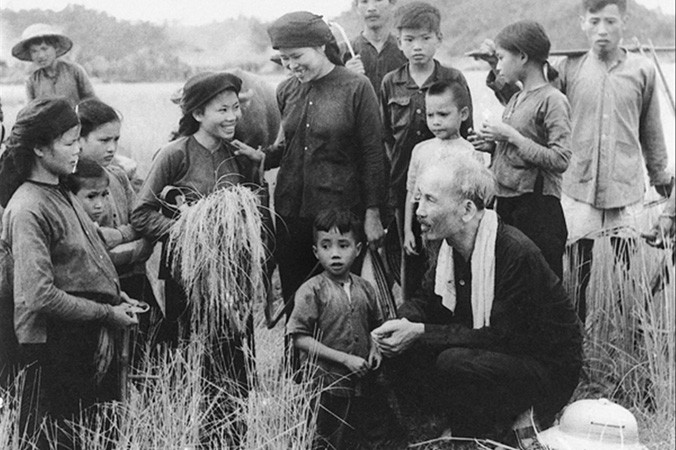 Chủ tịch Hồ Chí Minh thăm hỏi nông dân Hợp tác xã Hùng Sơn (huyện Đại Từ, tỉnh Thái Nguyên) đang gặt lúa, năm 1954. Ảnh: Tư liệu.