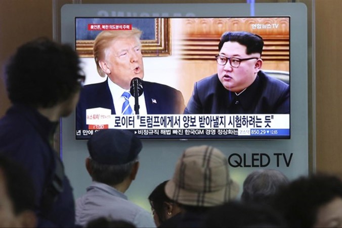 Người dân Hàn Quốc xem chương trình tin tức về Tổng thống Mỹ Donald Trump và nhà lãnh đạo Triều Tiên Kim Jong-un trên màn hình tại một ga tàu ở Seoul.