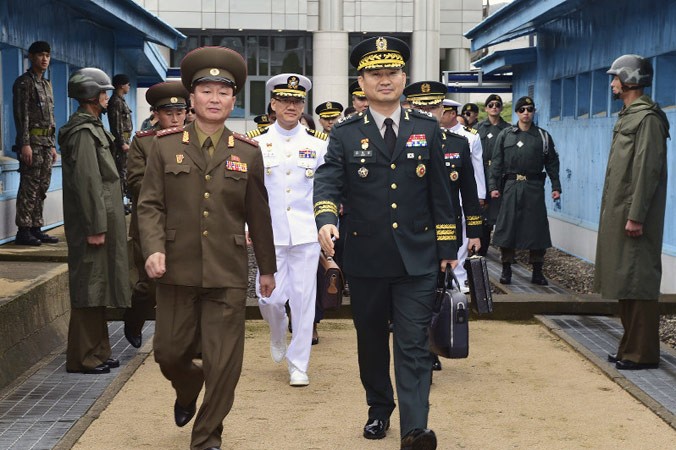 Trung tướng quân đội Hàn Quốc Kim Do-gyun (phải) bước qua biên giới Hàn Quốc-Triều Tiên, bên cạnh là một sỹ quan Triều Tiên. Ảnh: AP.