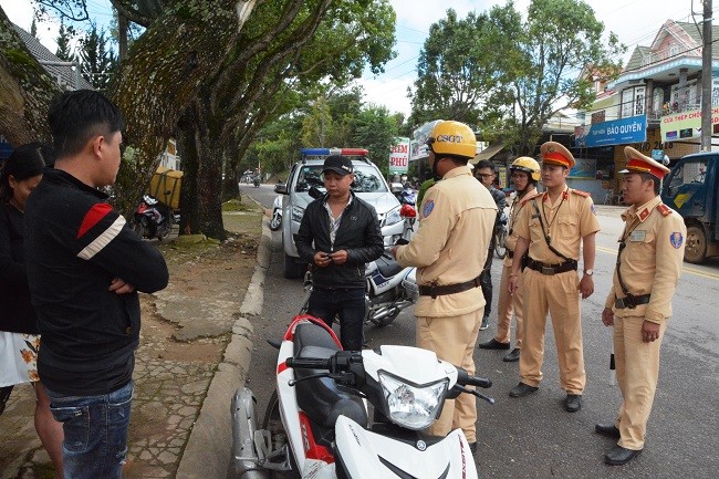 CSGT TP Đà Lạt xử lý một thanh niên đi xe gắn máy không đội mũ bảo hiểm có biểu hiện làm “cò” đặc sản. Ảnh: CAND