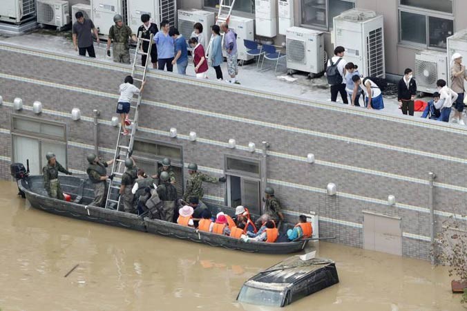 Các lực lượng phòng vệ đưa người dân ra khỏi vùng lụt tại tỉnh Okayama. Ảnh: Kyodo.