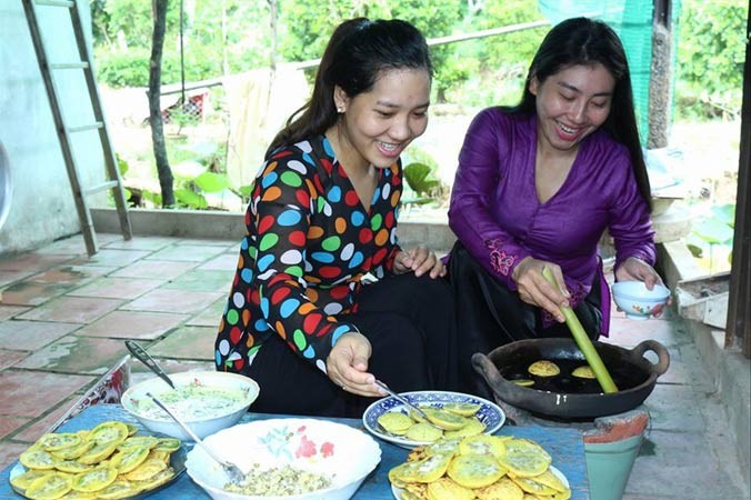 Nghệ nhân Lê Thị Bé Bảy (phải) hướng dẫn khách làm bánh. Ảnh: K. Mai.