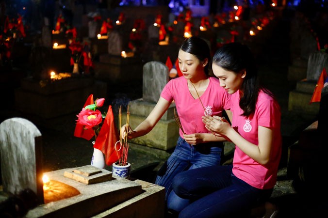 Các thí sinh HHVN tham gia thắp hương và thắp nến tại nghĩa trang Việt – Lào. Ảnh: Như Ý.