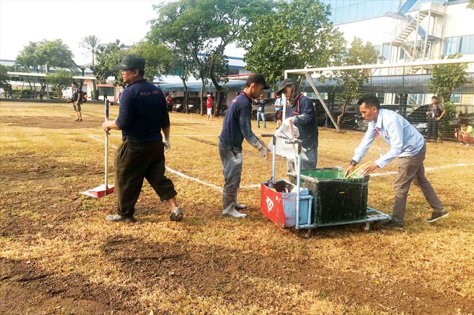 Nhân viên phục vụ nhà máy Samsung tại Tây Java dọn dẹp mặt sân trong khuôn viên nhà máy cho ÐT Olympic Việt Nam có buổi tập đầu tiên và duy nhất trước trận đấu với Olympic Pakistan vào chiều nay. Ảnh: N.P.