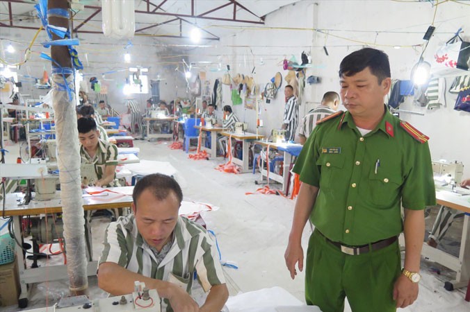 Trung tá Lâm Văn Lợi cùng các phạm nhân làm việc tại xưởng may.