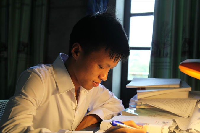 Vương Xuân Hoàng bên góc học tập ở nhà. Ảnh: N.T.